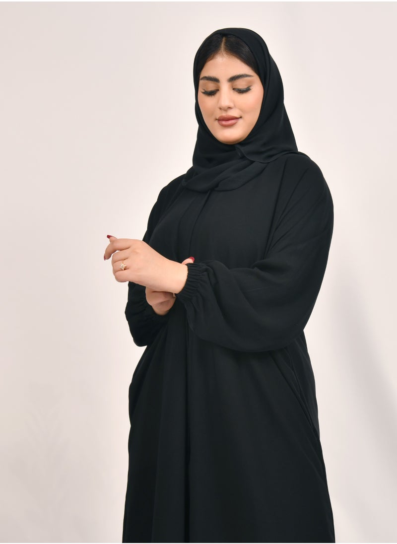 HAWRAA ABAYA - Plain black abaya with snap closure, ruffled sleeves and hidden pockets - Image 1