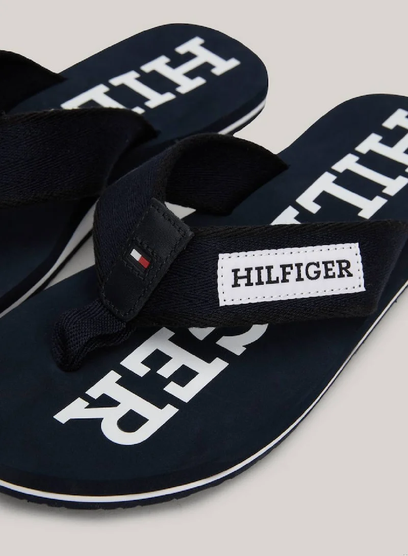 TOMMY HILFIGER Men's Hilfiger Monotype Webbing Strap Flip-Flops -  Polyester webbing upper, Blue