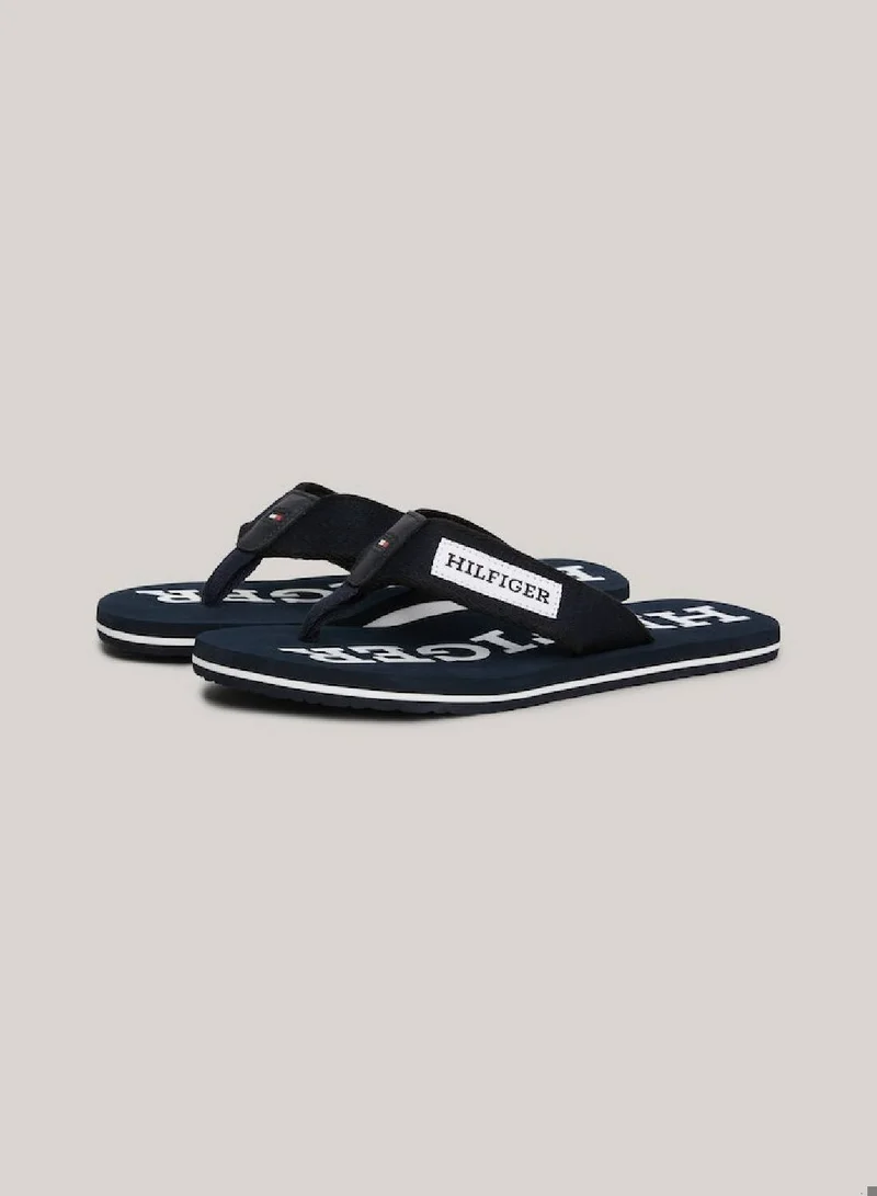 TOMMY HILFIGER Men's Hilfiger Monotype Webbing Strap Flip-Flops -  Polyester webbing upper, Blue