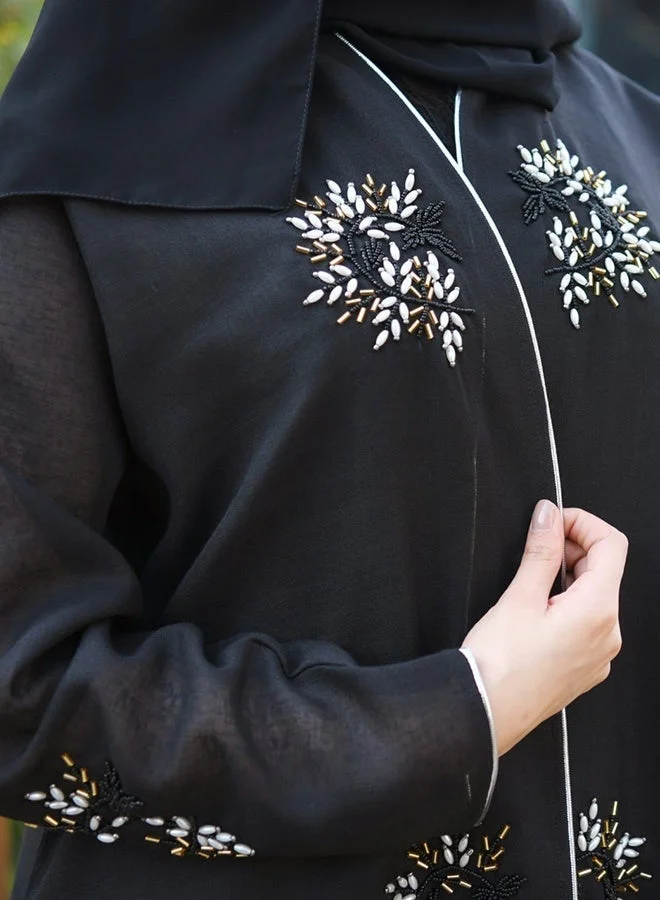 HAWRAA ABAYA Black wrap abaya adorned with prominent embellishments and braided trim along the edges and sleeves