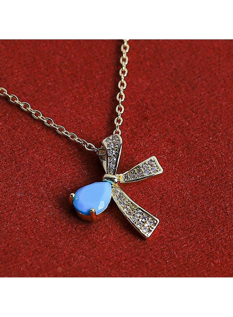 FLUFFY A golden necklace with a captivating bow design, featuring a vibrant oval-shaped gemstone at its center  - Image 3