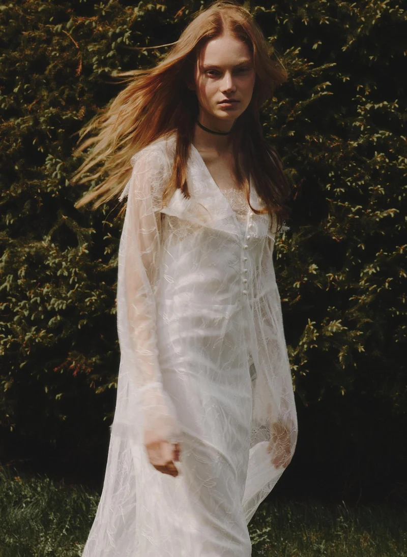 Lace cape with pearlescent button fastening