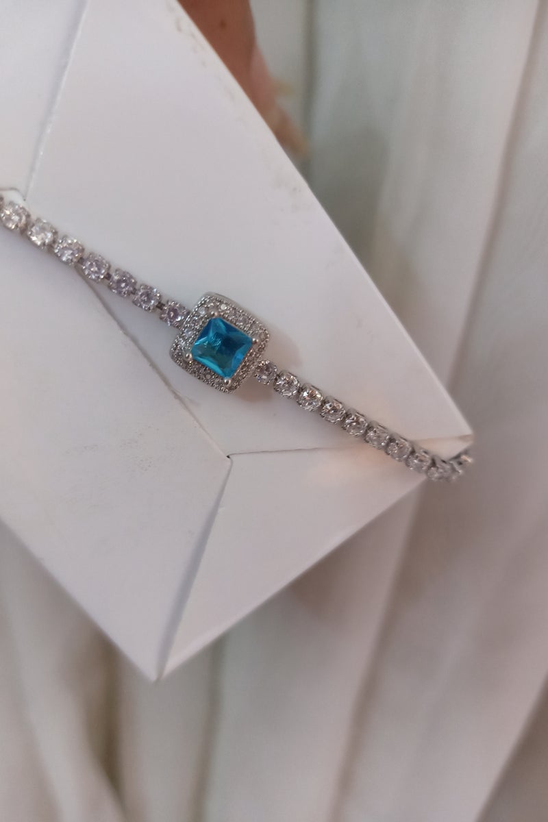 Luxuria Tennis bracelet with a blue/turquoise stone surrounded by white stones. - Image 4