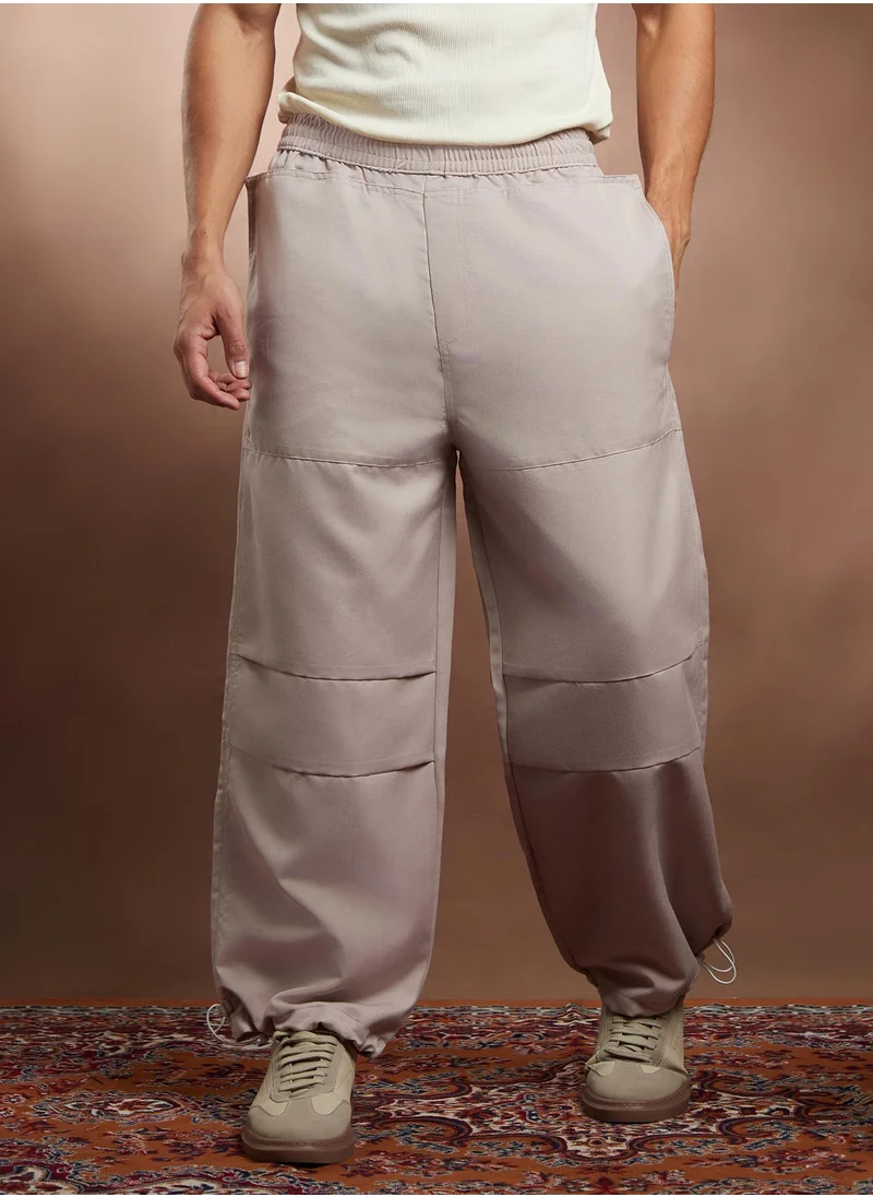 Campus Sutra Campus Sutra Men's Saltbox Beige Panelled Parachute Trousers For Casual Wear | Mid-Rise | Relaxed Fit | Elasticated Waist Closure | Cargo Pants Crafted With Comfort Fit For Everyday Wear