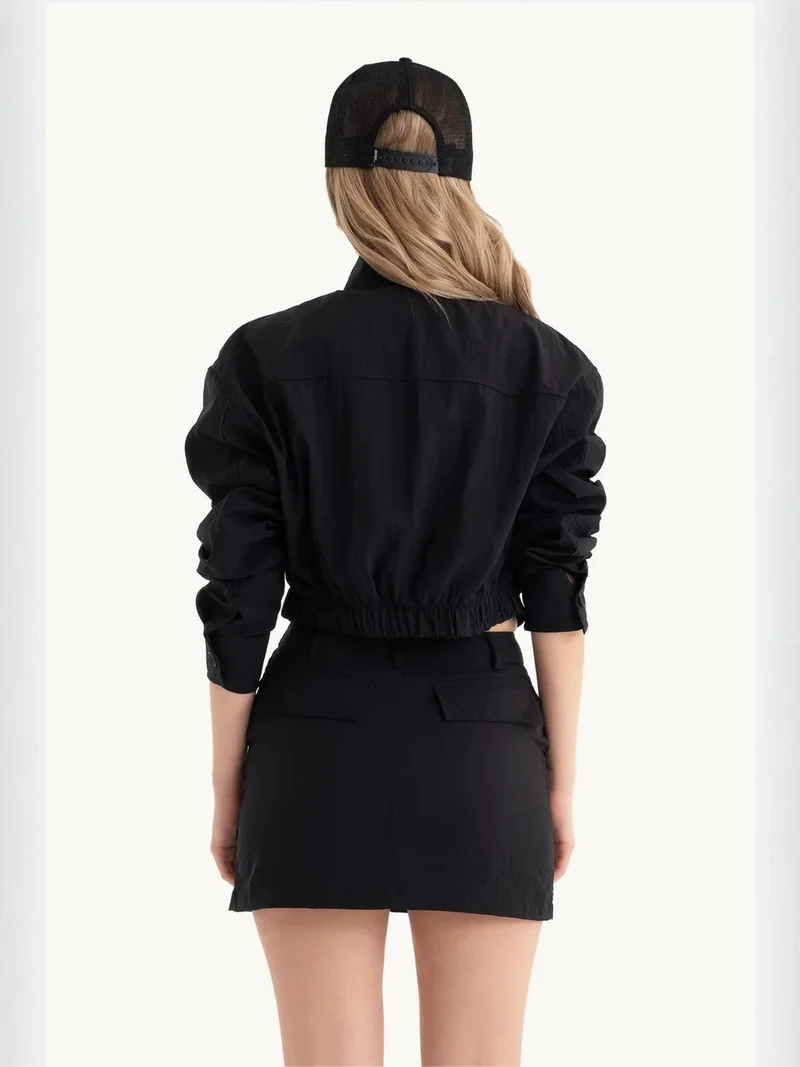 زوبعة تنورة قصيرة بخصر عالٍ بتفاصيل جيب