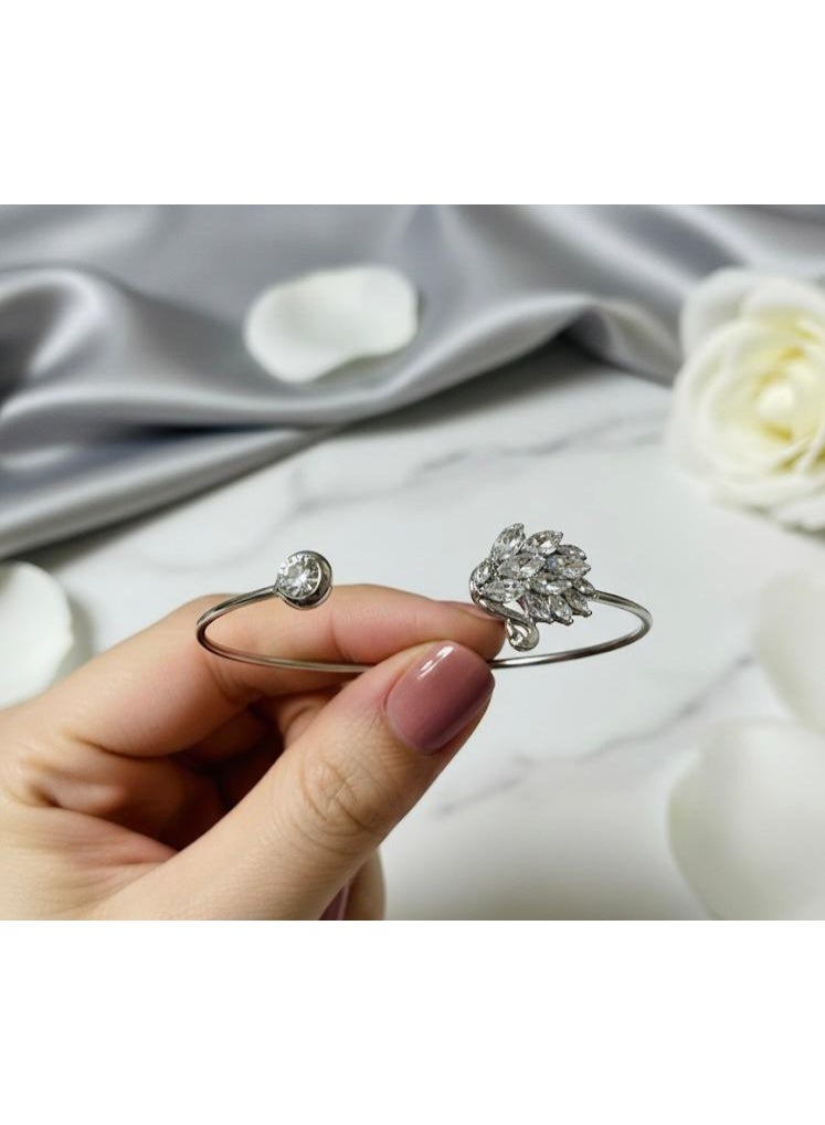 A silver-colored bracelet with an open design that combines a round zircon stone and a collection of shiny stones in the shape of a feather, a modern elegance that catches the eye. - Image 3