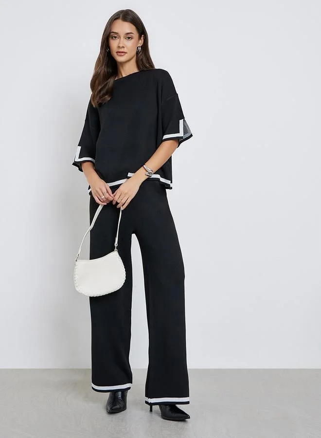 ستايلي بلوزة محبوكة بقصة مريحة وتفاصيل مُتباينة