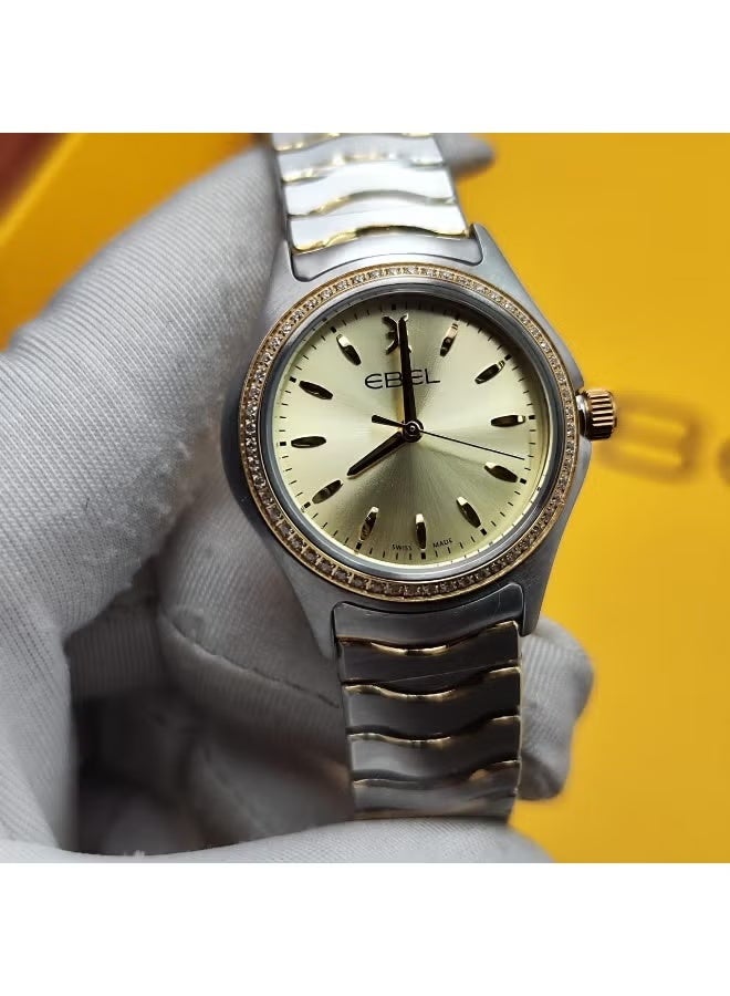 The Ebel women's watch features a classic design with a distinctive wave-shaped strap.