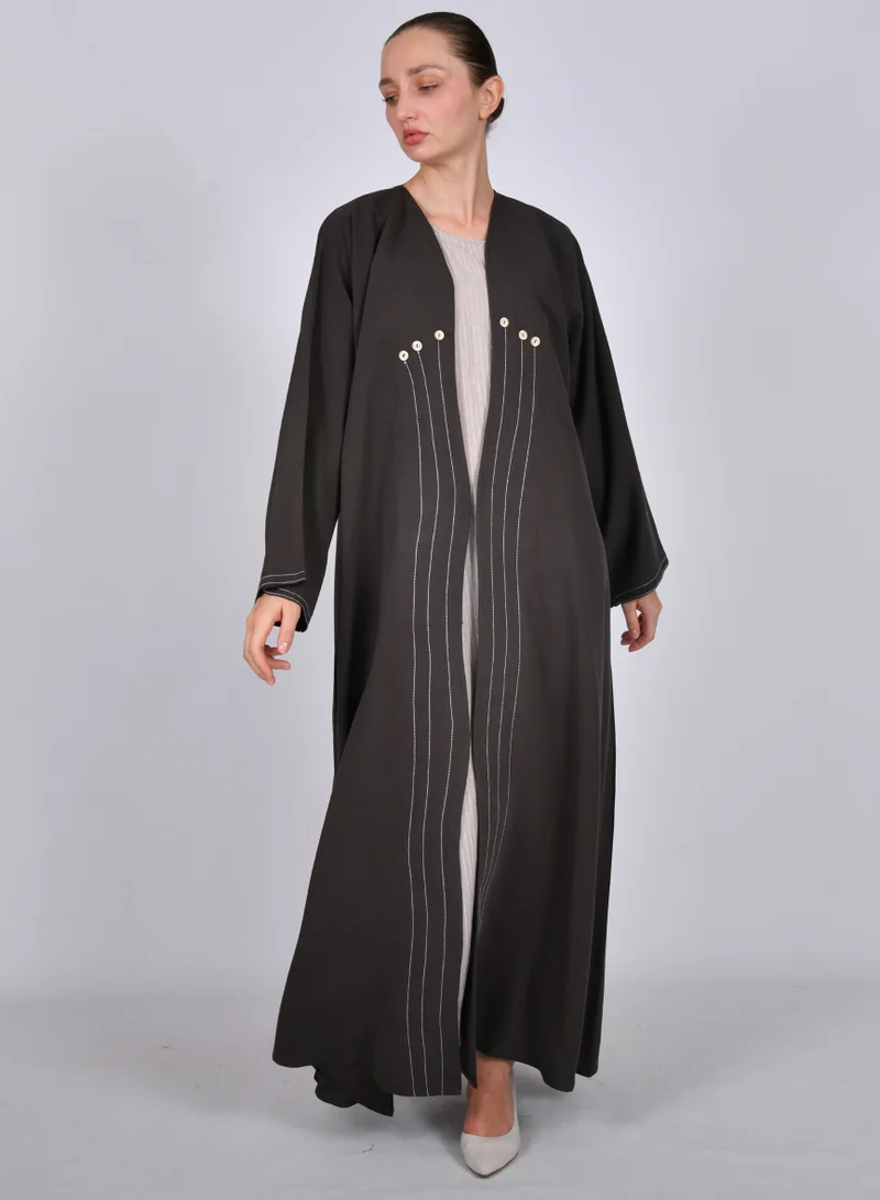 HAWRAA ABAYA Brown wrap abaya with a quarter-circle, flowing white embroidery and decorated with buttons