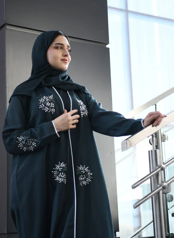 HAWRAA ABAYA Dark green wrap abaya adorned with prominent embellishments and braided trim along the edges and sleeves