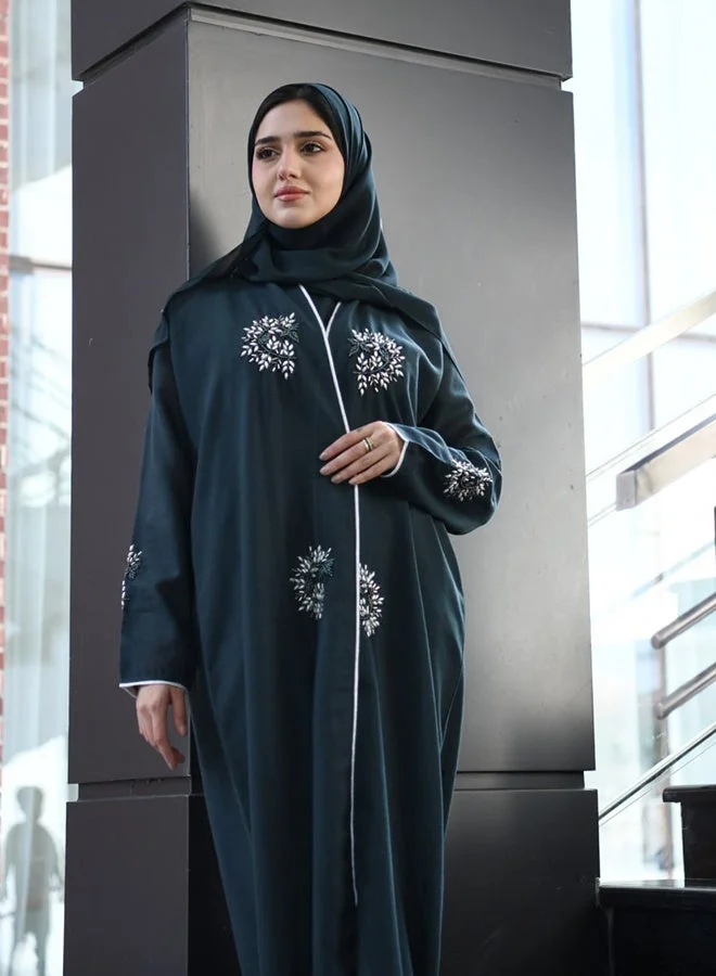 HAWRAA ABAYA Dark green wrap abaya adorned with prominent embellishments and braided trim along the edges and sleeves