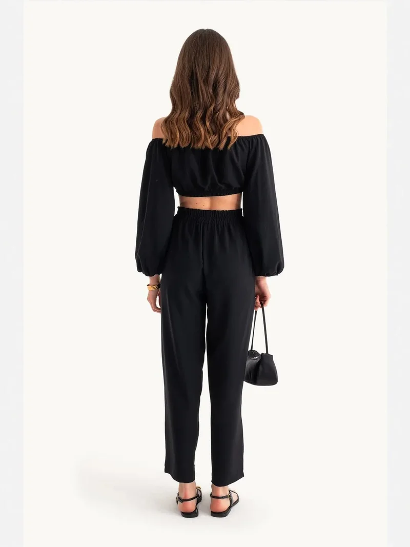 زوبعة قطعتان: بلوزة قصيرة بأكتاف مكشوفة وأكمام بالون وسراويل مستقيمة بخصر مطاطي متوسط الارتفاع