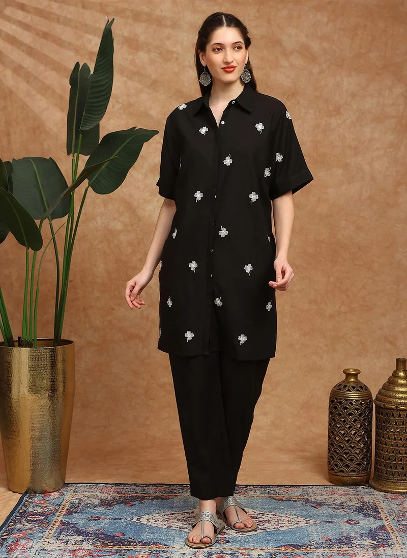 جلو باص طقم كورتا نسائي باللون الأسود مع بنطلون مطرز بالزهور وأكمام ممتدة