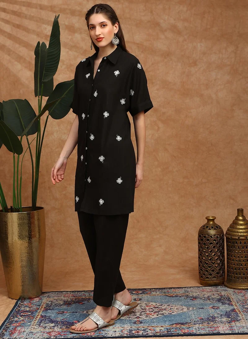 جلو باص طقم كورتا نسائي باللون الأسود مع بنطلون مطرز بالزهور وأكمام ممتدة
