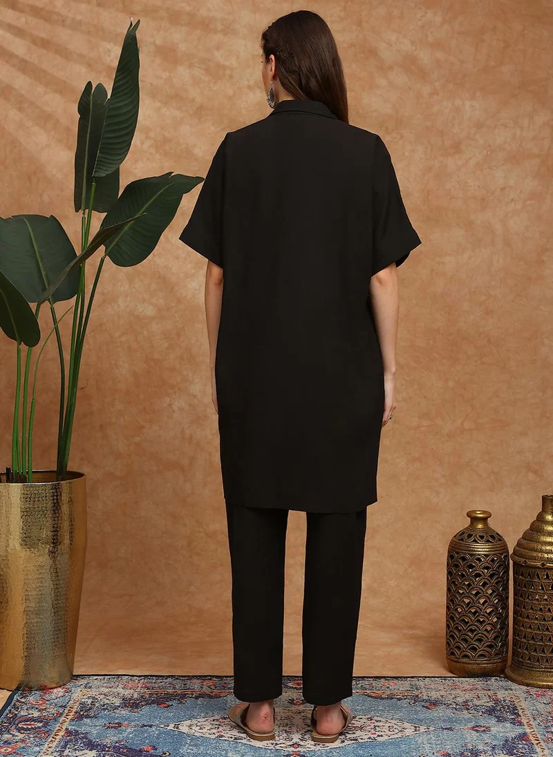 جلو باص طقم كورتا نسائي باللون الأسود مع بنطلون مطرز بالزهور وأكمام ممتدة