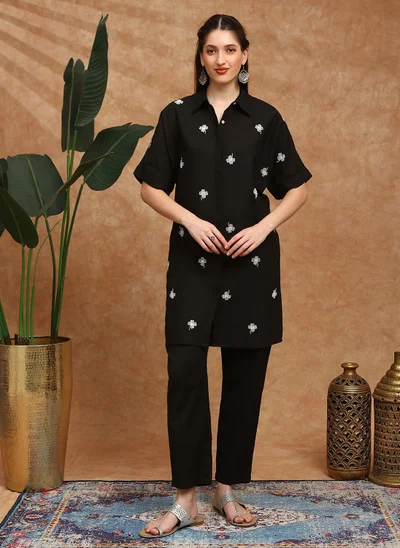 جلو باص طقم كورتا نسائي باللون الأسود مع بنطلون مطرز بالزهور وأكمام ممتدة