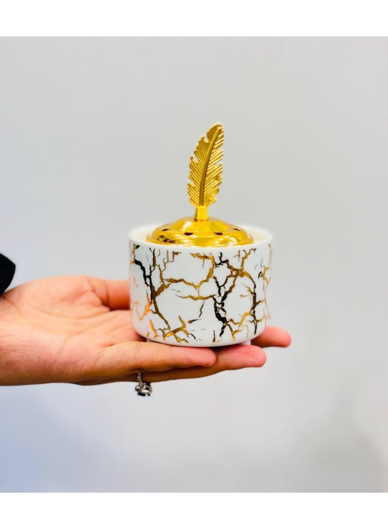 NAMA An Elegant And Compact Incense Burner (Mabkhara) Made Of White Ceramic. It Features A Modern Yet Luxurious Design, With Its Exterior Surface Decorated With A Cracked Or Marble-Vein Pattern In Shiny Gold.
