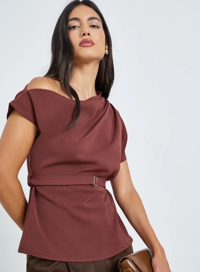 ستايلي بلوزة بكتف واحد ومزينة بحزام خصر