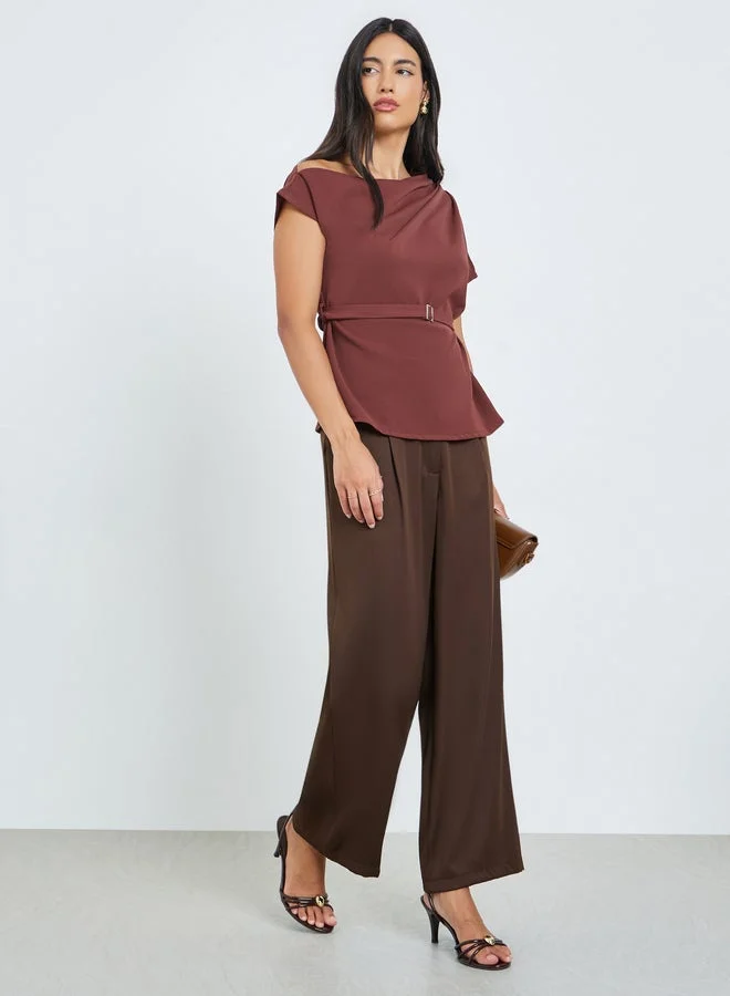 ستايلي بلوزة بكتف واحد ومزينة بحزام خصر