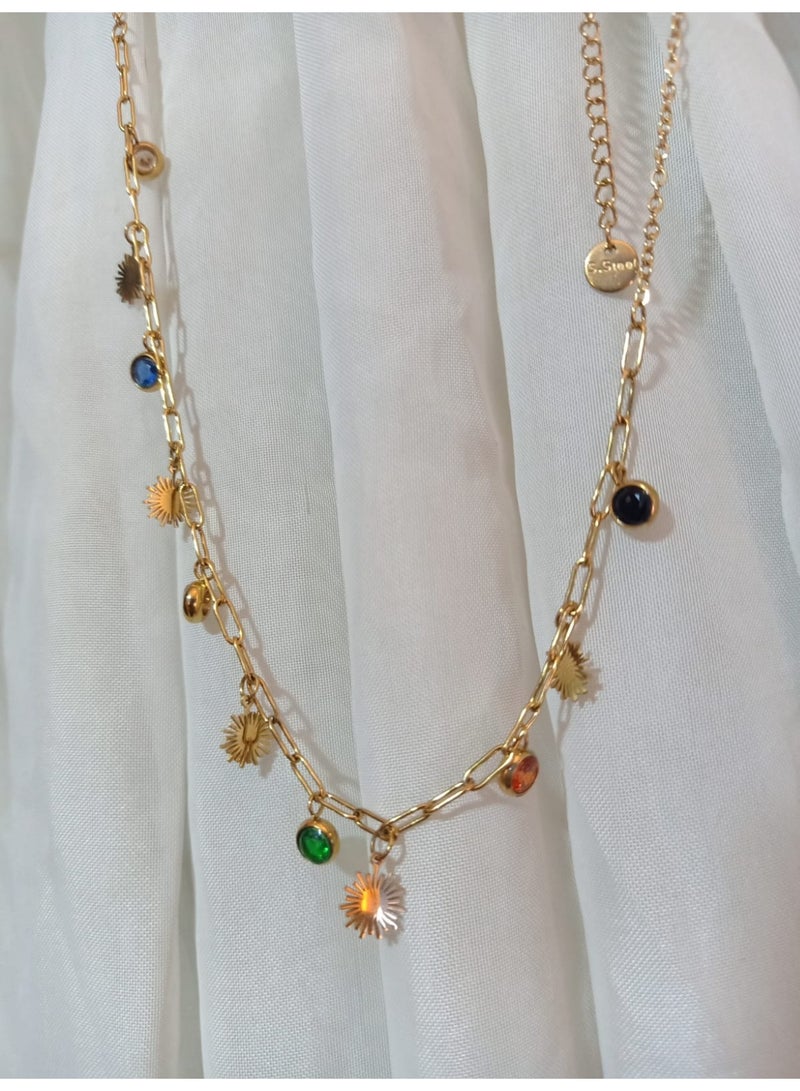 Luxuria This striking gold chain necklace features a modern design combining sun-shaped pendants and colorful gemstones. The chain itself is made of thick links, giving it a distinctive look. - Image 3