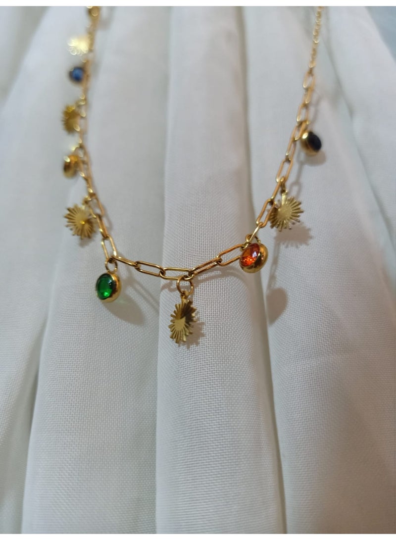 Luxuria This striking gold chain necklace features a modern design combining sun-shaped pendants and colorful gemstones. The chain itself is made of thick links, giving it a distinctive look. - Image 4