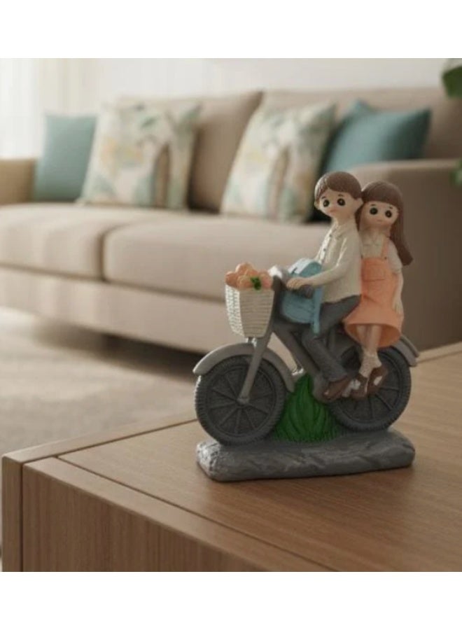 أي كي دي سي تمثال صغير لزوجين رومانسيين من البوليريسين من AKDC يركبان دراجة هوائية - ديكور حب برتقالي ورمادي 12 سم - Image 1