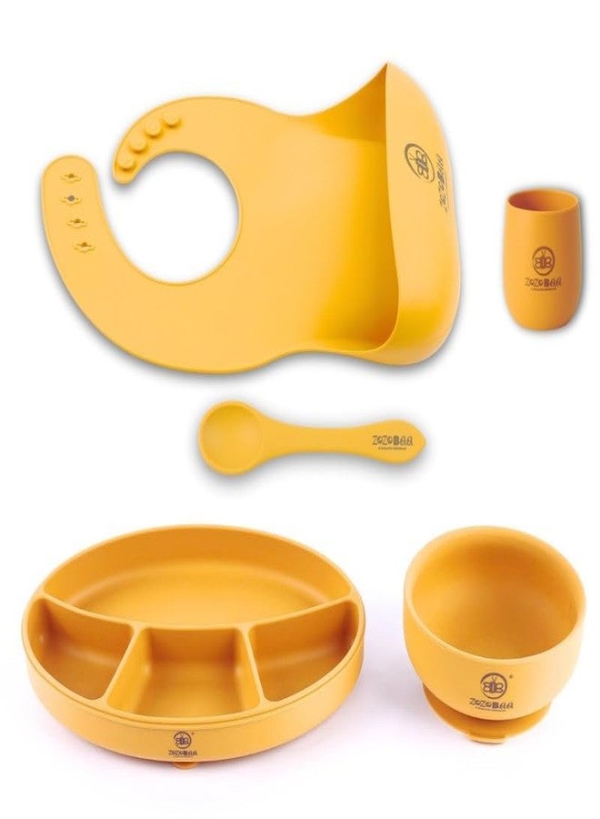ZoZoBaa Silicone Feeding Set Including Baby Bib,Long Spoon, Tiny Open Cup, Suction Base Oval Plate & Bowl for Toddler |Solid Cutlery Set| Easy Wipe Clean| Baby Weaning Sets (5 Pc), [Mango Yellow] - Image 1