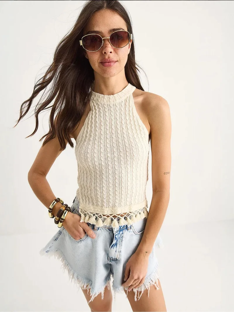 بيانكو لوتشي بلوزة قصيرة ضيقة بياقة هالتر من لوكسي بنقوش بارزة