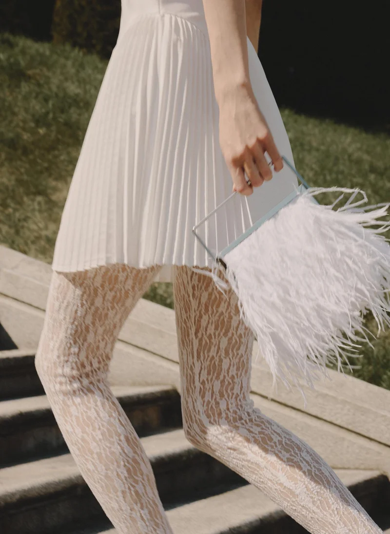 Clutch bag with feather detailing and a metal handle