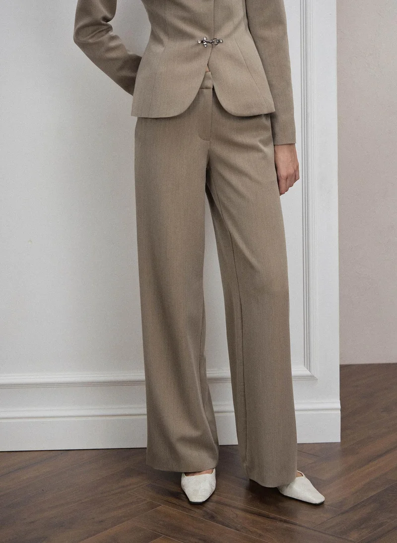 Loose-fitting trousers with metal clasps