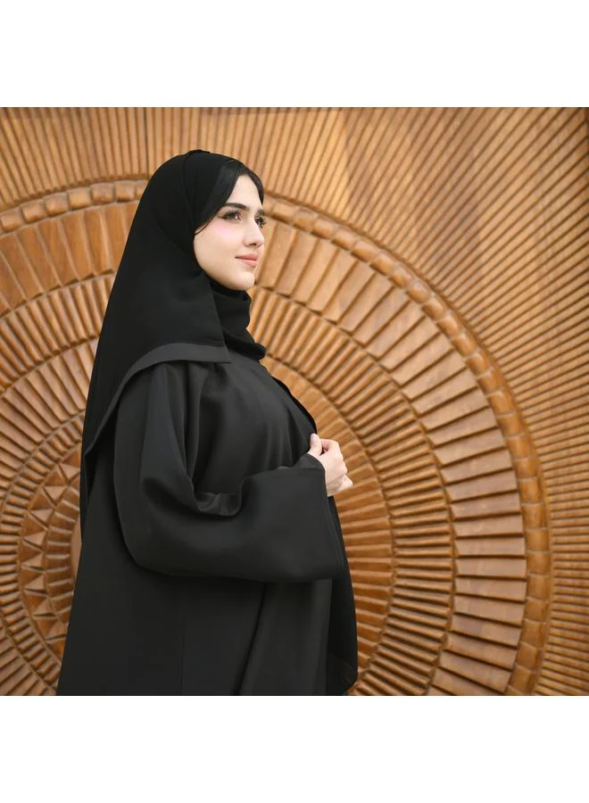 HAWRAA ABAYA Black wrap abaya made of rich fabric decorated with black embroidery and studs at the bottom with a button closure