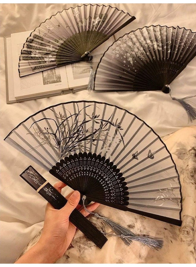 An elegant, foldable bamboo fan featuring a comfortable, handcrafted design; black with assorted floral patterns, and lightweight for portability. - Image 3