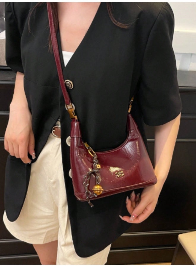 arab This mini women's shoulder bag features a glossy faux leather finish and a compact, elegant design – perfect for daily outings or special occasions. Comes in a rich burgundy color with a stylish tassel and gold-tone bell charm. Equipped with a secure top zipper and soft inner lining to protect your essentials.  Features:  Material: Glossy high-quality PU leather  Closure: Sturdy top zipper  Inner lining for added protection  Decorative tassel charm included  Lightweight and compact  Great for parties, dinners, and daily use  - Image 3