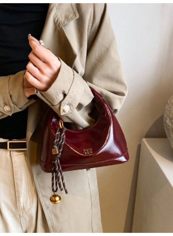arab This mini women's shoulder bag features a glossy faux leather finish and a compact, elegant design – perfect for daily outings or special occasions. Comes in a rich burgundy color with a stylish tassel and gold-tone bell charm. Equipped with a secure top zipper and soft inner lining to protect your essentials.  Features:  Material: Glossy high-quality PU leather  Closure: Sturdy top zipper  Inner lining for added protection  Decorative tassel charm included  Lightweight and compact  Great for parties, dinners, and daily use  - Image 2