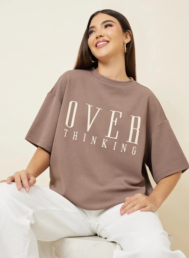 ستايلي تيشيرت واسع بتفاصيل بارزة وأكتاف منخفضة