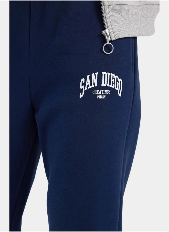ديفاكتو Slogan Print Elasticated Cuff Joggers with Pockets by Styli
