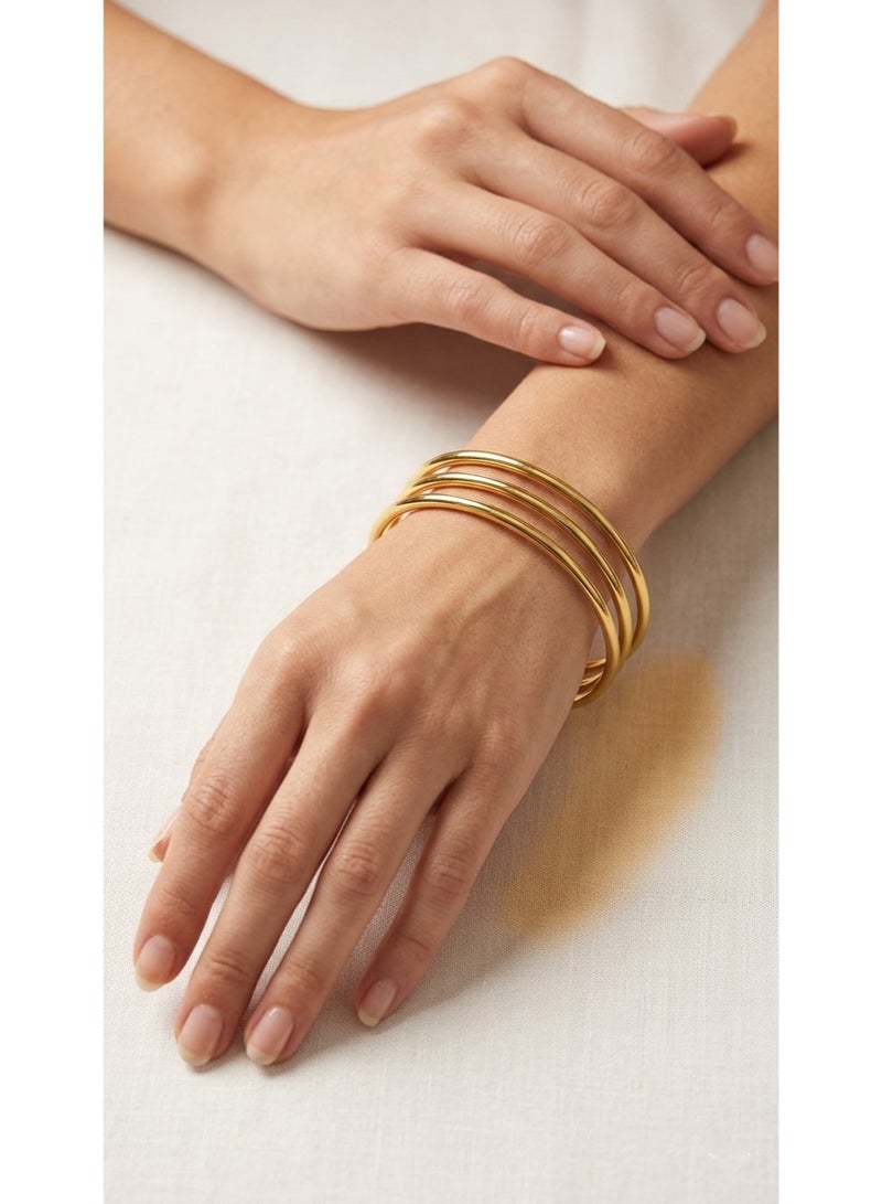 A classic and smooth open gold bangle bracelet set featuring a sophisticated multi-band design with three stacked hoops for a complete and feminine look on your wrist.