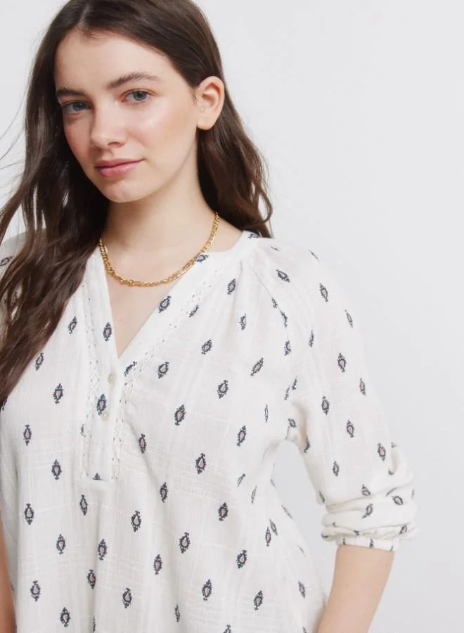 Springfield  White long sleeve blue print blouse. Round mandarin collar. V-neckline. Lace detail on the neckline. Button fastening on the front and elasticated cuffs. This garment is made from sustainable cotton. for Women | Best Price UAE