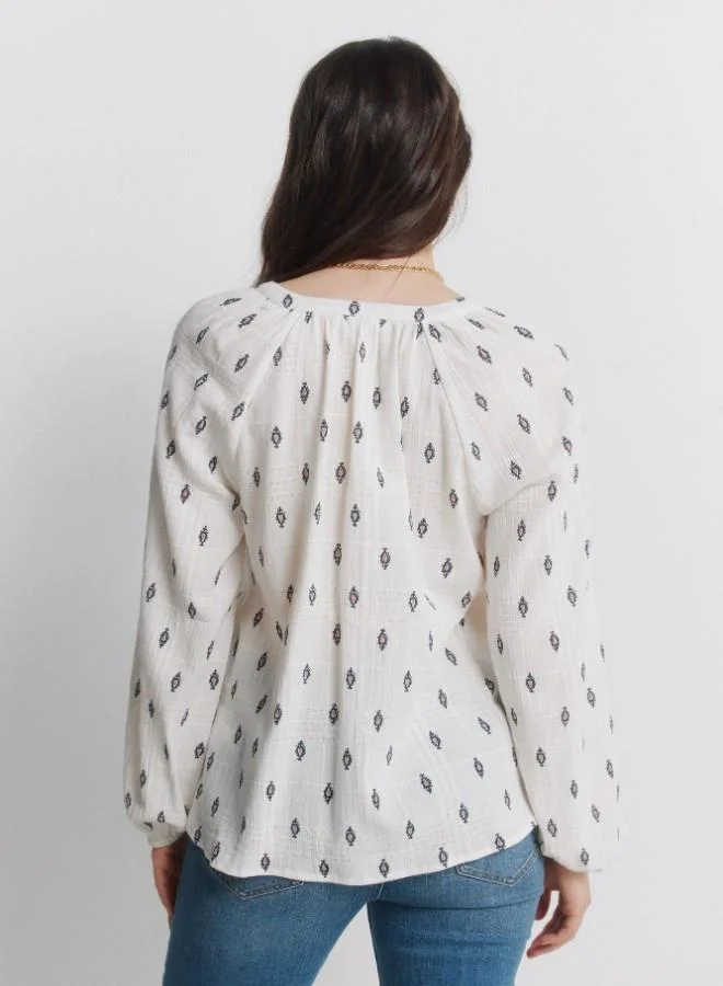 Springfield  White long sleeve blue print blouse. Round mandarin collar. V-neckline. Lace detail on the neckline. Button fastening on the front and elasticated cuffs. This garment is made from sustainable cotton. for Women | Best Price UAE