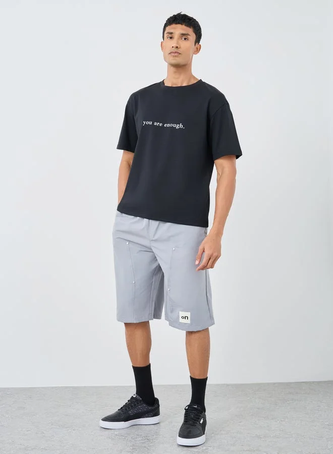 ستايلي تي شيرت فضفاض بياقة دائرية وطبعة شعار ستايلي