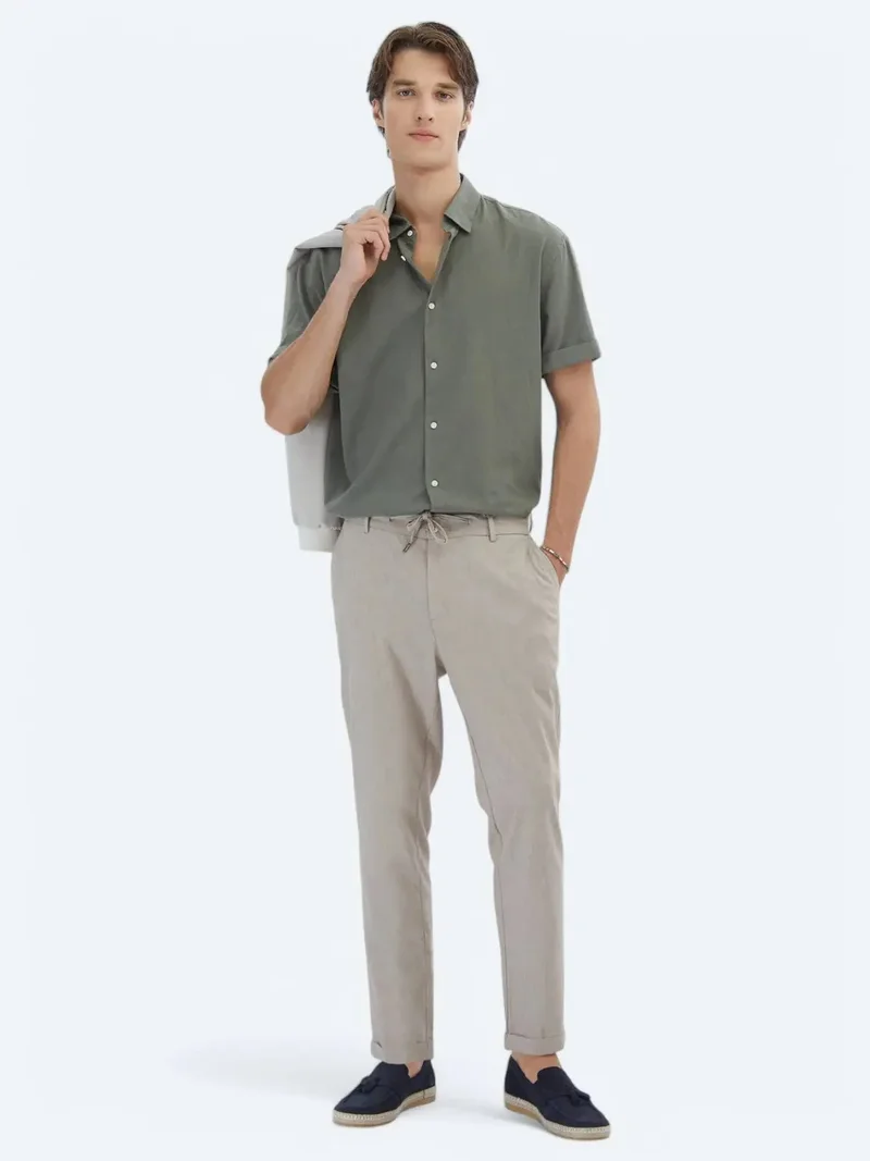 كيب بنطال رياضي قطني مخلوط بلون كاكي، بقصة مريحة وعصرية.