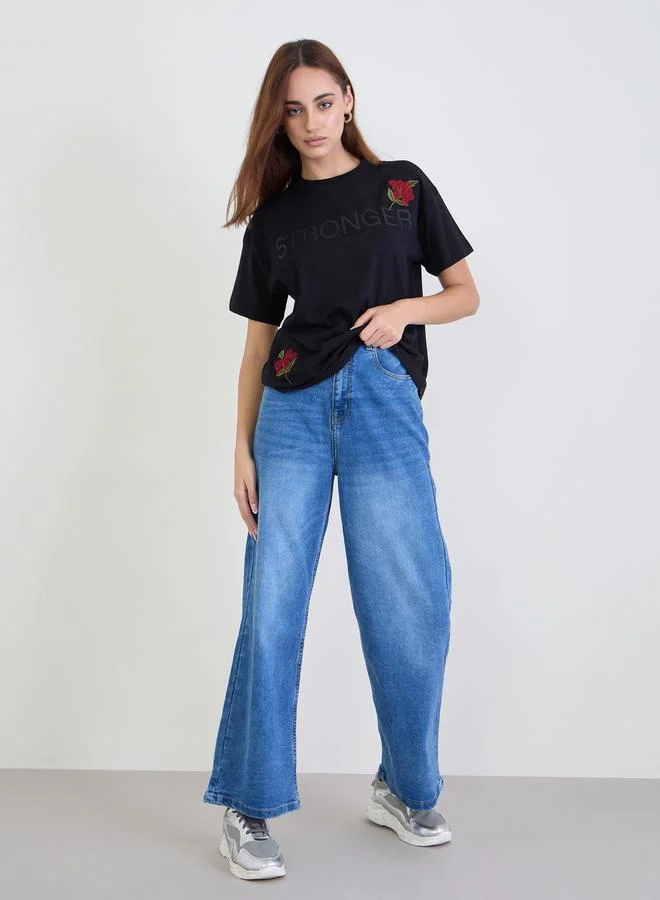 ستايلي تيشيرت بوكسي بطبعة كتابة وتفاصيل مُطرّزة