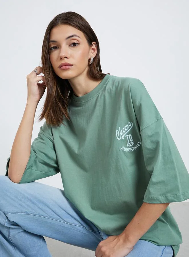 ستايلي تيشيرت فضفاض بتفاصيل كتابة مُطرزة