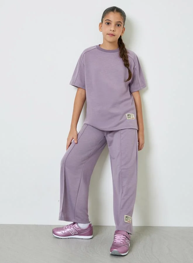 Styli Teens Badge Relaxed Fit T-Shirt And Wide Leg Joggers Set