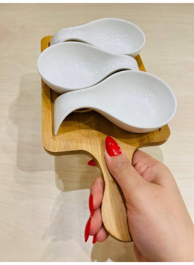 An elegant touch for any table setting 🤍✨ These bowls feature a sleek, fluid design in brilliant white porcelain that exudes cleanliness and sophistication. They are paired with a natural bamboo base that complements the look, adding balance and distinctive beauty.  Designed for serving sauces and delicious accompaniments 👌 Perfect for ketchup, mayonnaise, mustard, melted cheese, dips, small appetizers, and even nuts. - Image 1