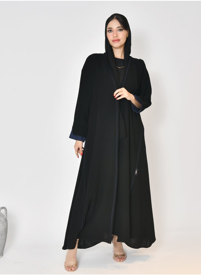 Black wrap abaya with quarter-cloth fabric, puff sleeves, and navy color overlapping on the sleeves and the front and side edges of the abaya in an arrow shape