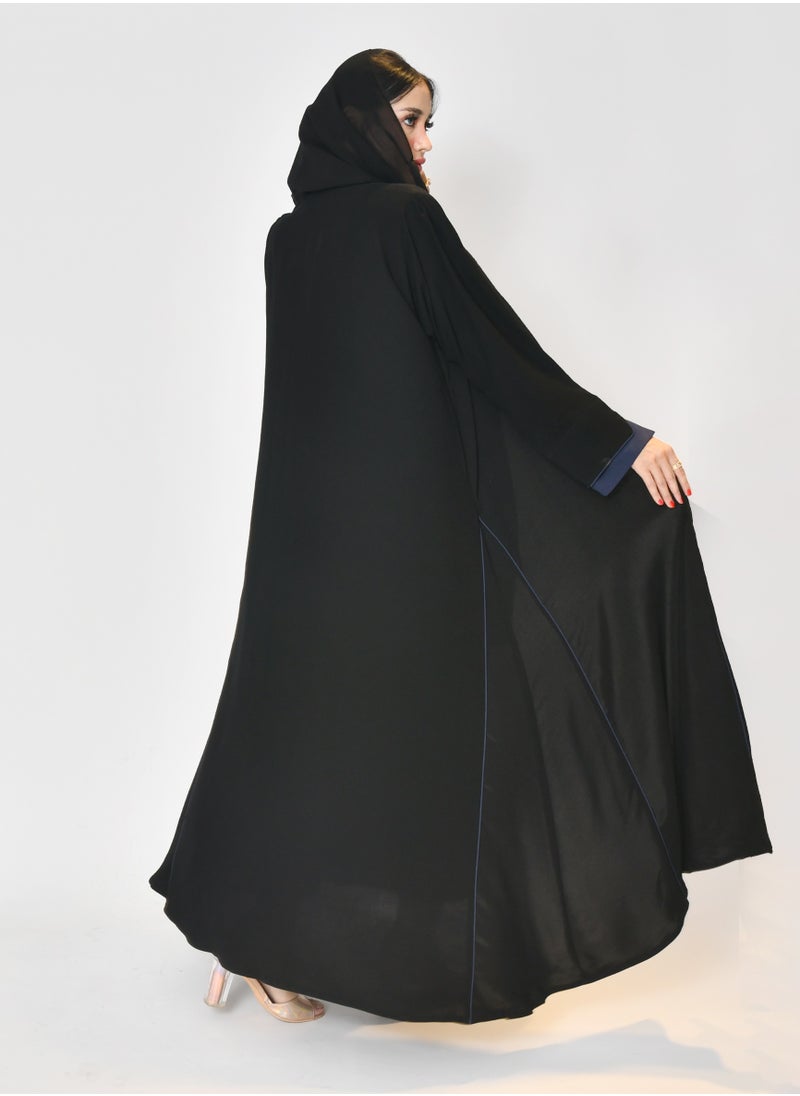 Black wrap abaya with quarter-cloth fabric, puff sleeves, and navy color overlapping on the sleeves and the front and side edges of the abaya in an arrow shape