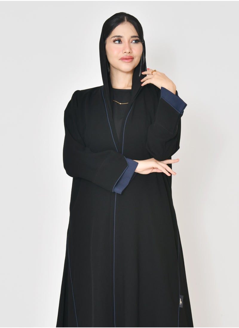 Black wrap abaya with quarter-cloth fabric, puff sleeves, and navy color overlapping on the sleeves and the front and side edges of the abaya in an arrow shape