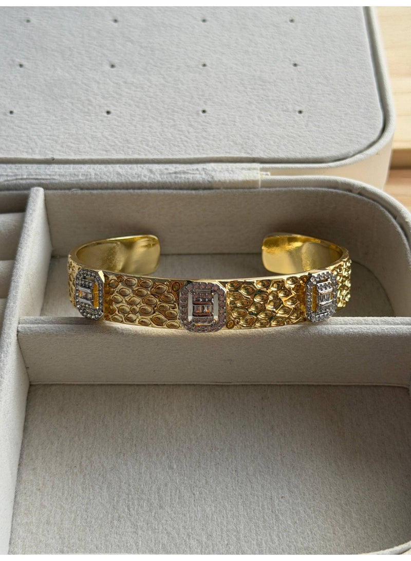 A stylish and modern gold bracelet, adorned with diamonds.