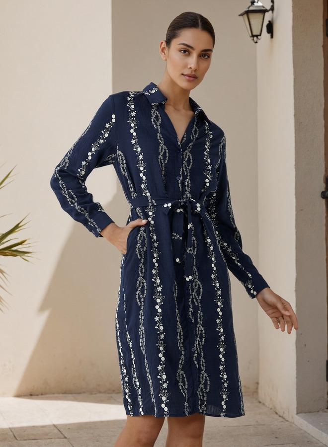 A knee-length dress with a belt and floral embroid...